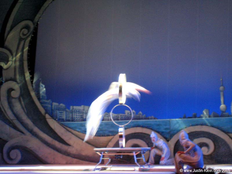 That is actually a person springing backwards off the ground, without the use of a trampoline, through the hoop.