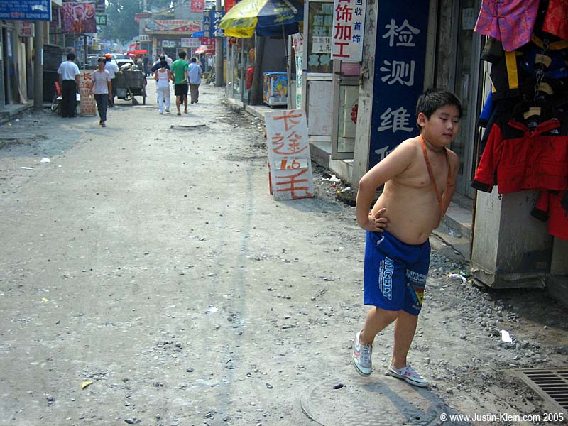 A Little Emperor roaming around shirtless in his neighborhood. Guys seem to roam shirtless about as often as they wear shirts in China.