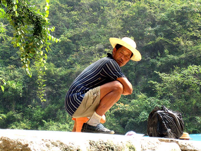 A farmer kneeling on a rock like Jeff in High School. 