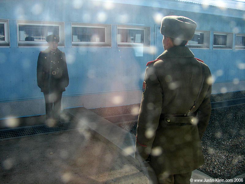 See that slightly raised concrete strip on the ground?  That's the actual line between the two countries.  Inside the conference room, I'm on the North Korean side of the border.  Check out those two communist soldiers faithfully guarding their side. 