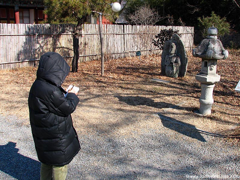 A child sketching a garden lantern.