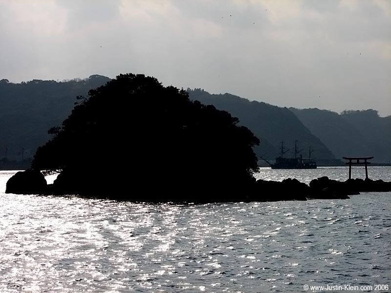 Off the coast of Shimoda, with a Black Ship replica visible in the distance. 