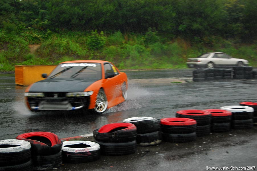 A car bursts into the camera frame in a full skid before slamming the accelerator and spraying me with water as it whips around to position itself for the next turn.
