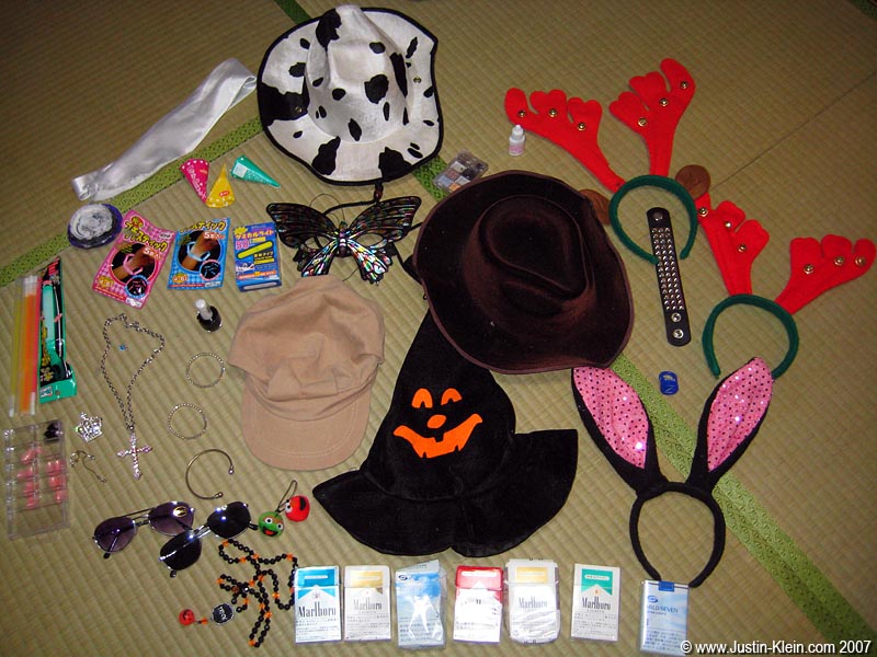 Our spoils of war, from the last three months of partying. Included here are some, but not all, of the random "bling" that was handed to Peder and I by friends, acquaintances, bartenders, and total strangers. Note that despite having received <i>seven</i> packets of cigarettes, neither of us smoke.