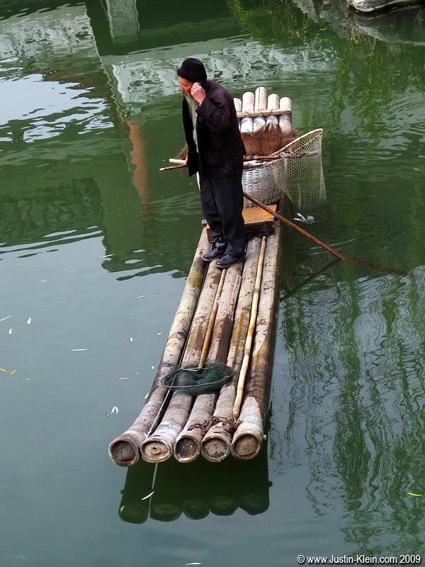 Remember my favorite photography theme in Kyoto? The old and the new? How about a bearded old fisherman on a bamboo raft...talking on a cellphone.