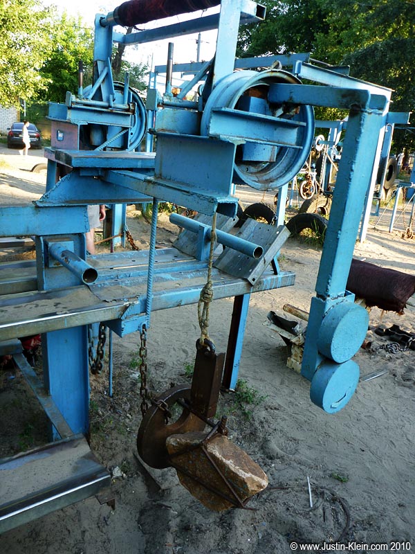 Check out the creative apparatus they're using for a weight stack! It looks like an anchor with an iron clothes hanger and a boulder dangling off one end.