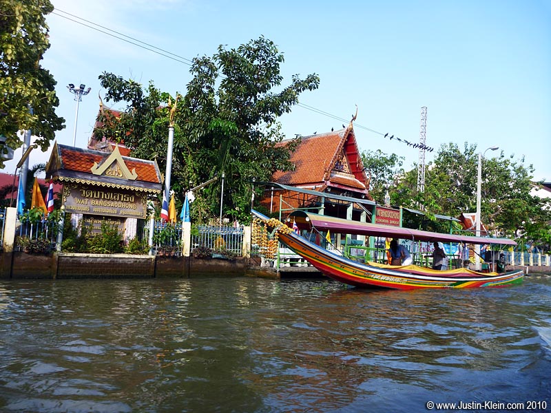 A water taxi stopping at a small temple.